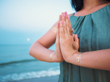 Silver and golden flash tattoo on female hands over sea or ocean background