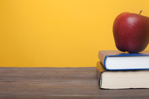 apple and books on a teacher's desk 