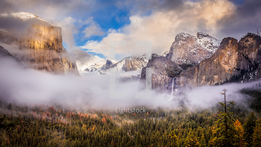 fog rising above a mountain valley and waterfall 