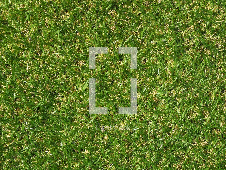 Green artificial synthetic grass meadow texture useful as a background