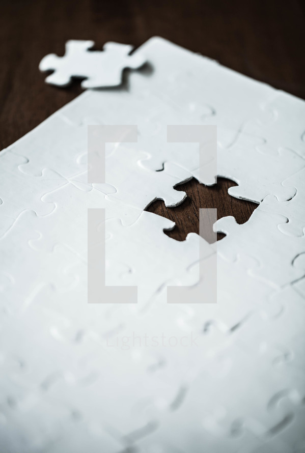 White jigsaw puzzle with piece missing.