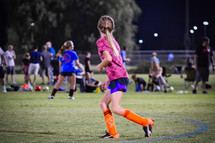 a girl running on the soccer field 