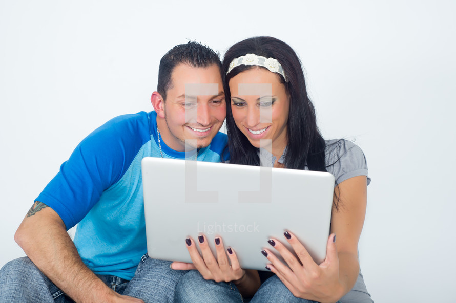 Couple holding a laptop computer.