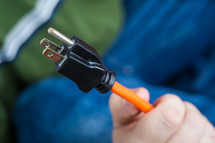 man holding a power cord plug