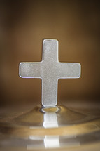 cross on the top of a communion tray 