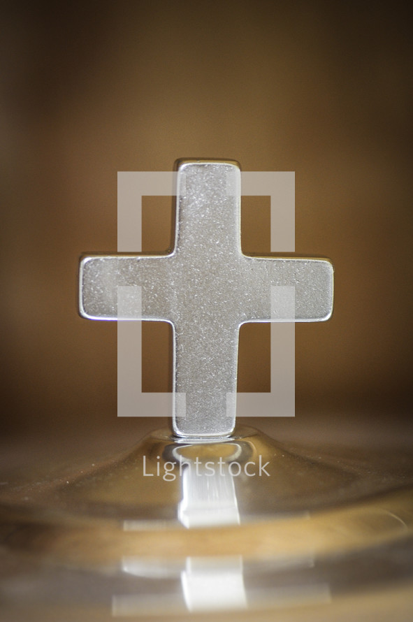 cross on the top of a communion tray 