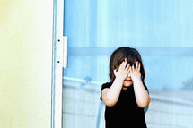 a child covering his face 