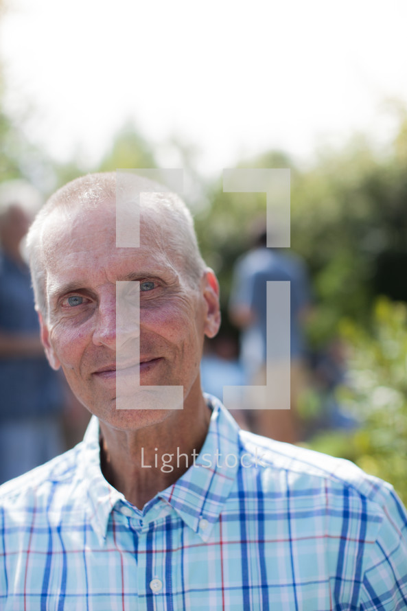 headshot of a man at an outdoor summer party 