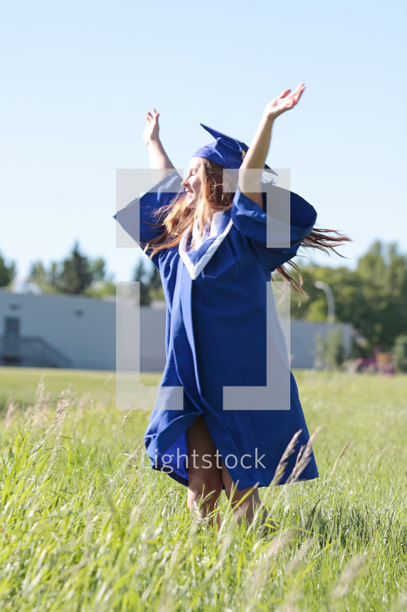 a student dances with joy on graduation day outside her school
