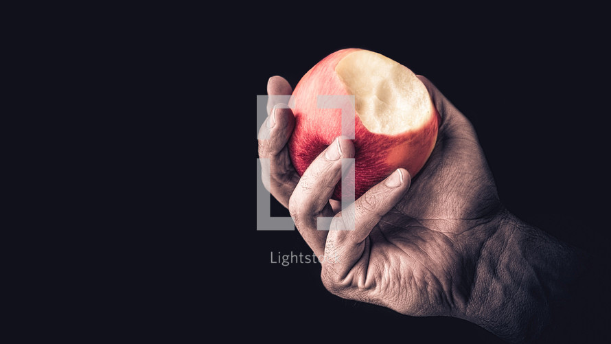 Hand holding an apple with a bite mark