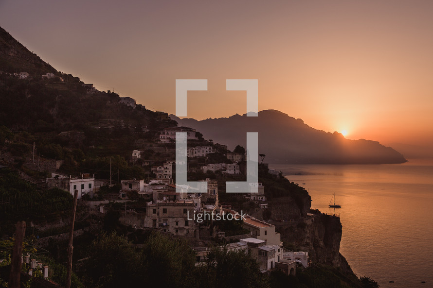 a village along a shoreline in Italy at sunset 