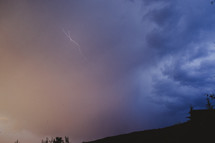 A lightning storm plays out on a hillside. 