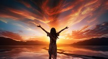 Woman with hands up in the air on the background of a beautiful sunset