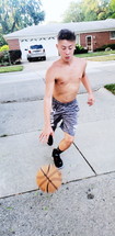 boy playing basketball in the driveway 