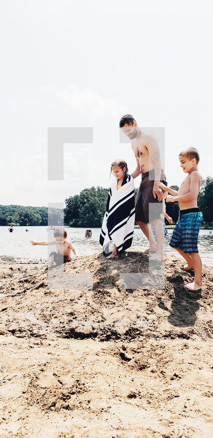 father on a beach with his kids 