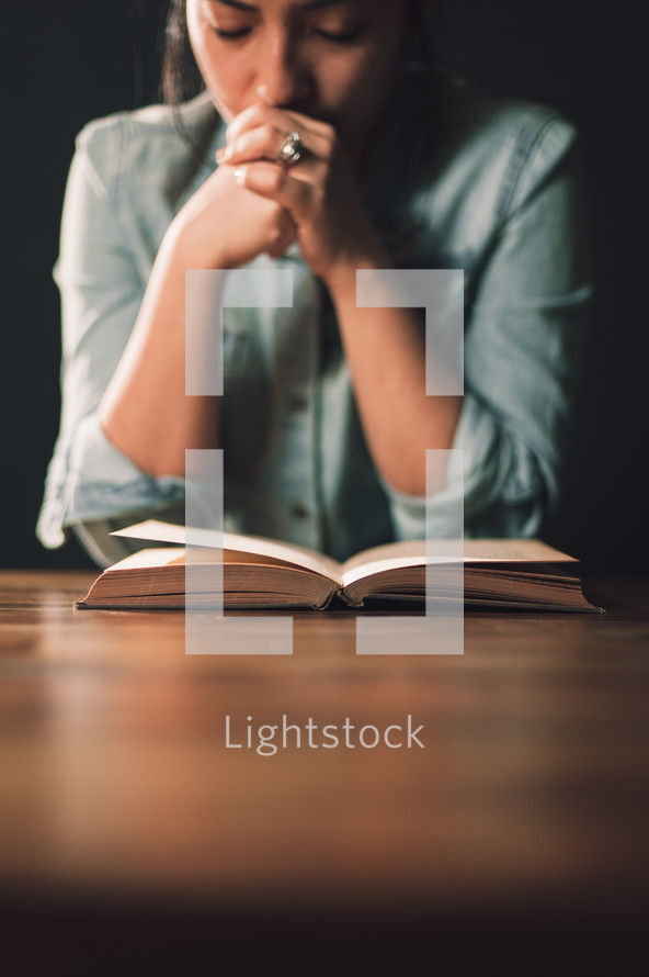 woman praying over a book 