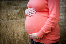 Pregnant woman holding belly.