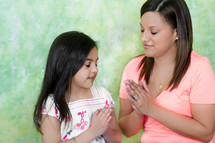 Mother and daughter in prayer.
