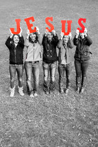Teens holding up the word JESUS