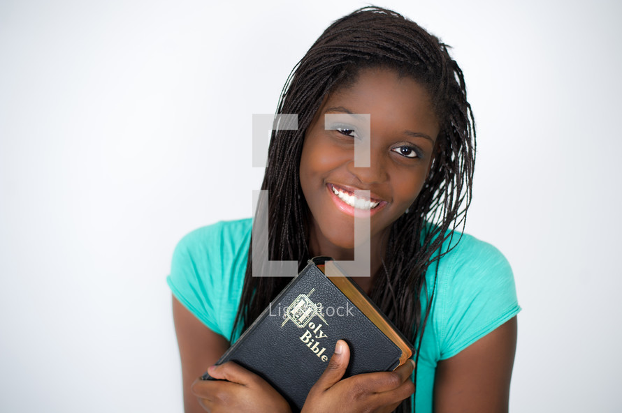 A teen girl holding a Bible. 