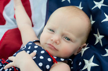 infant girl sleeping on an American flag 