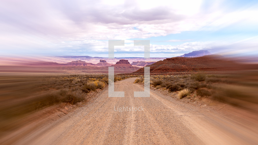 Dirt road in southwest with motion blur and clouds