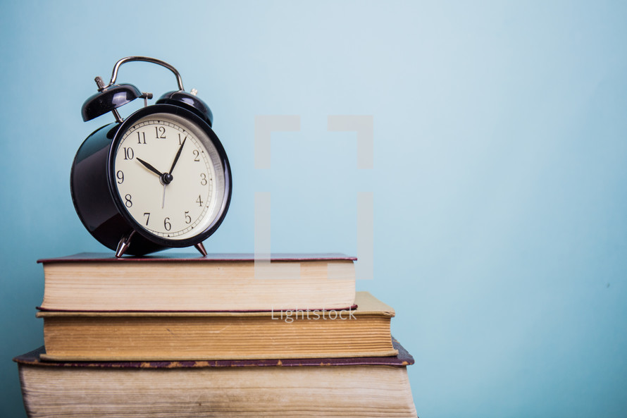 alarm clock and a stack of books 