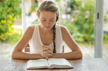 a woman reading a Bible and praying in the morning 