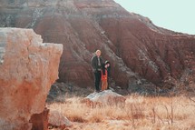 man and his sons in front of a red rock cliff