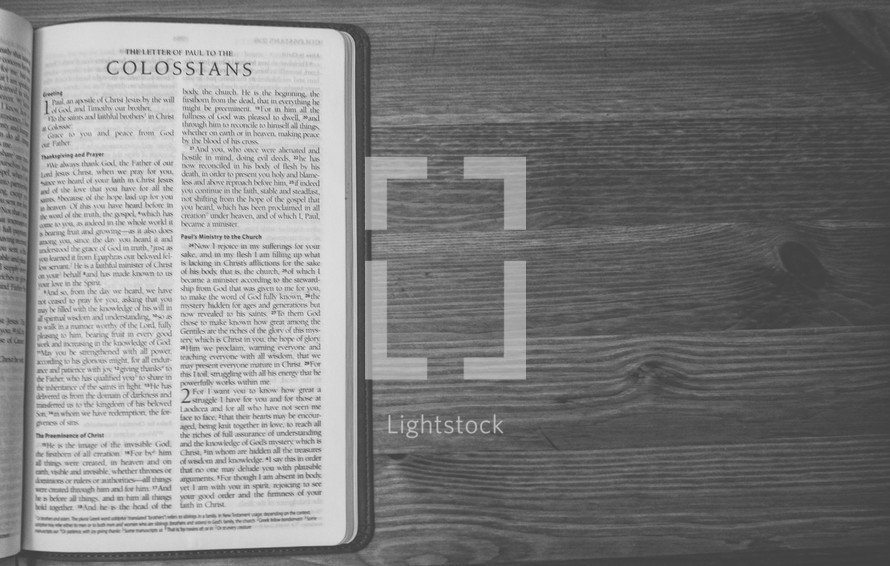 Bible on a wooden table open to the Letter of Paul to the Colossians.