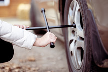 a woman changing a tire 