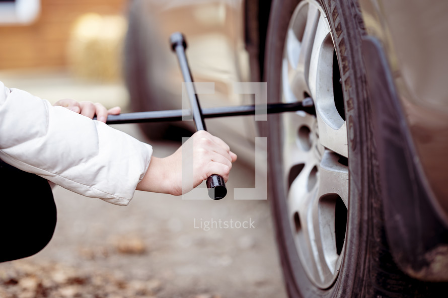 a woman changing a tire 