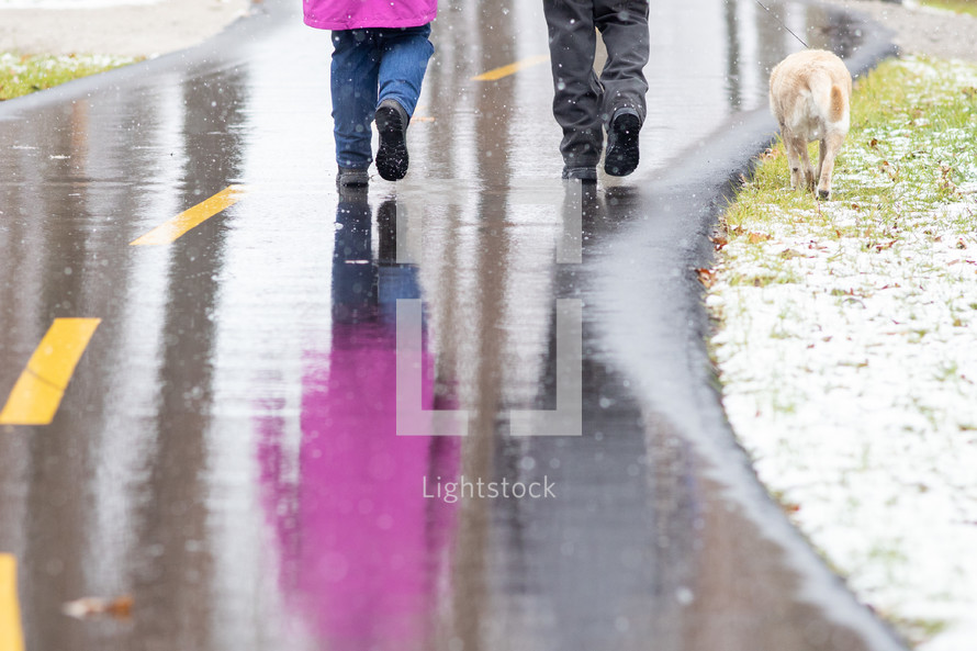 reflection of people walking on wet asphalt 