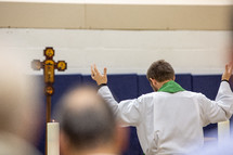 pastor praying with hands raised 