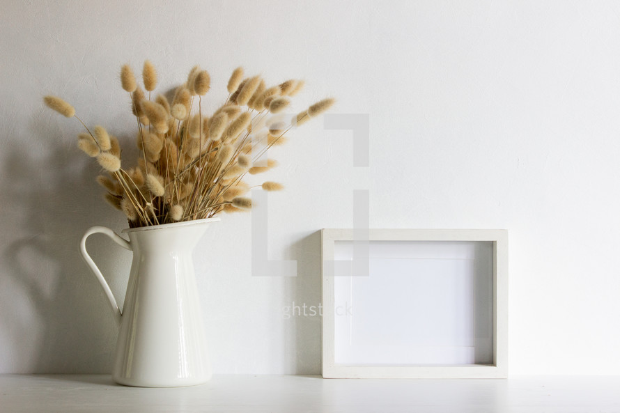 fuzzy grasses in a pitcher and blank frame 