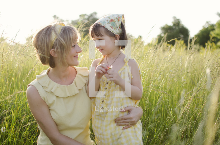 Mother and daughter in grass field