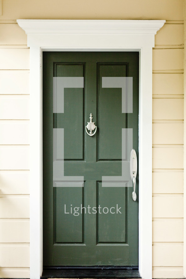 A green door with a door knocker.