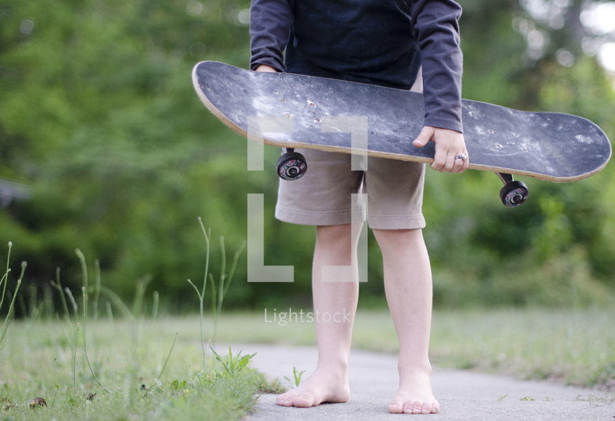 teenage boy holding a skateboard