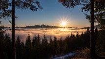 Beautiful sunset in forest nature with foggy clouds moving in mountains valley in peaceful evening of alpine landscape Time lapse
