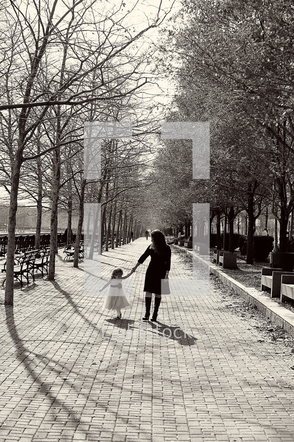 mother walking with her daughter  in a park
