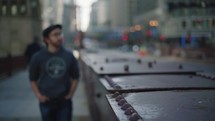 Out of focus young man walking along a city sidewalk