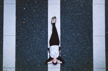 woman lying on a white line 
