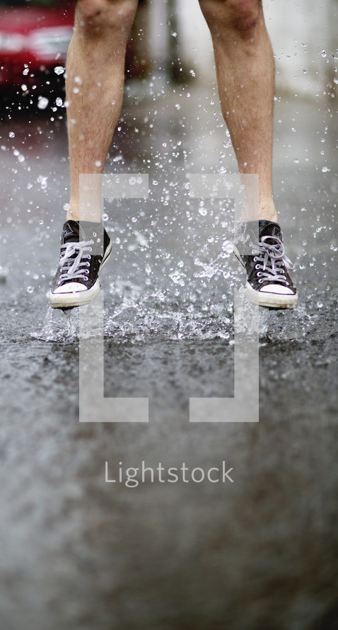 a man jumping in a puddle 