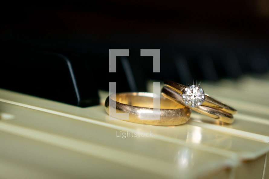 gold wedding rings on a piano  