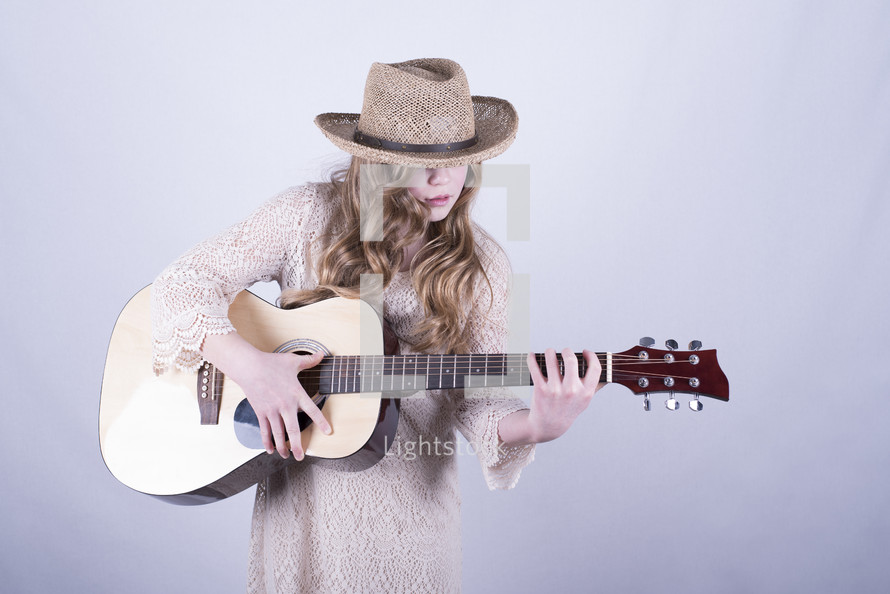 teen girl playing a guitar 