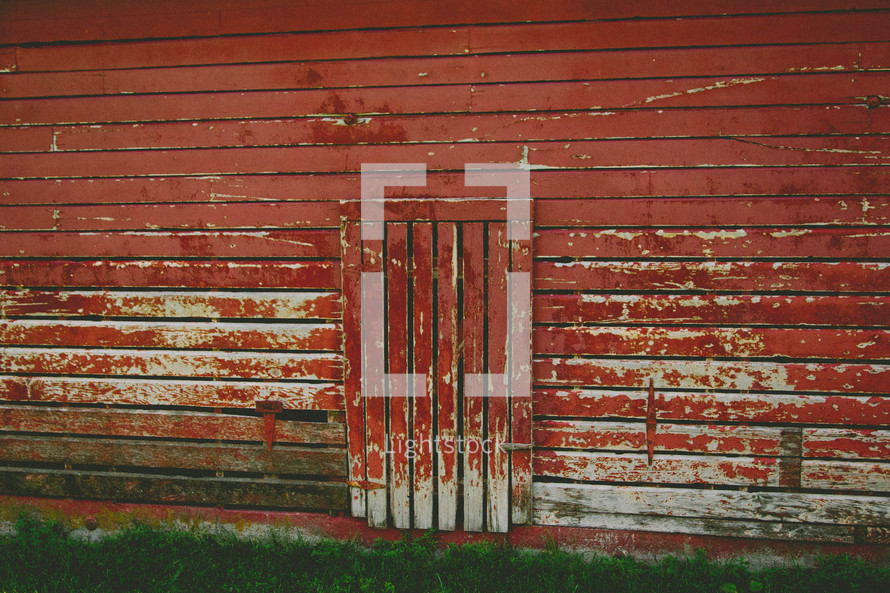 door to a weathered red barn 