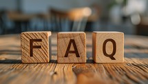  Wooden blocks spell FAQ on table