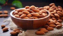 Almond nuts in wooden bowl on sackcloth and dark wooden background