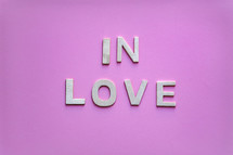 in love wooden letters on the pink background