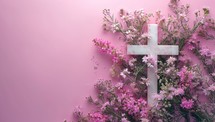 White cross with flowers on a pink background. Christian concept.